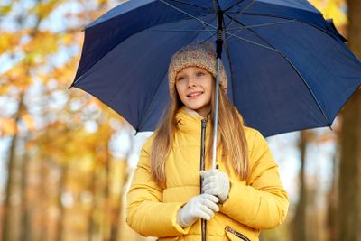happy girl with umbrella at autumn park