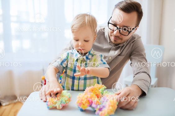 father and son playing with ball clay at home