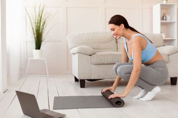 Fit Woman With Rolling Mat Preparing For Training At Home