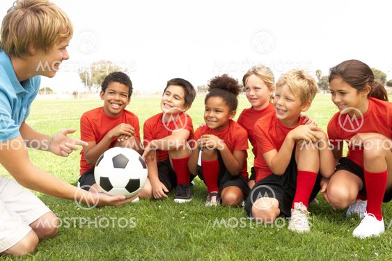 Young Boys And Girls In Football Team With Coach
