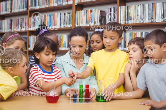 Pupils and teacher doing science in library