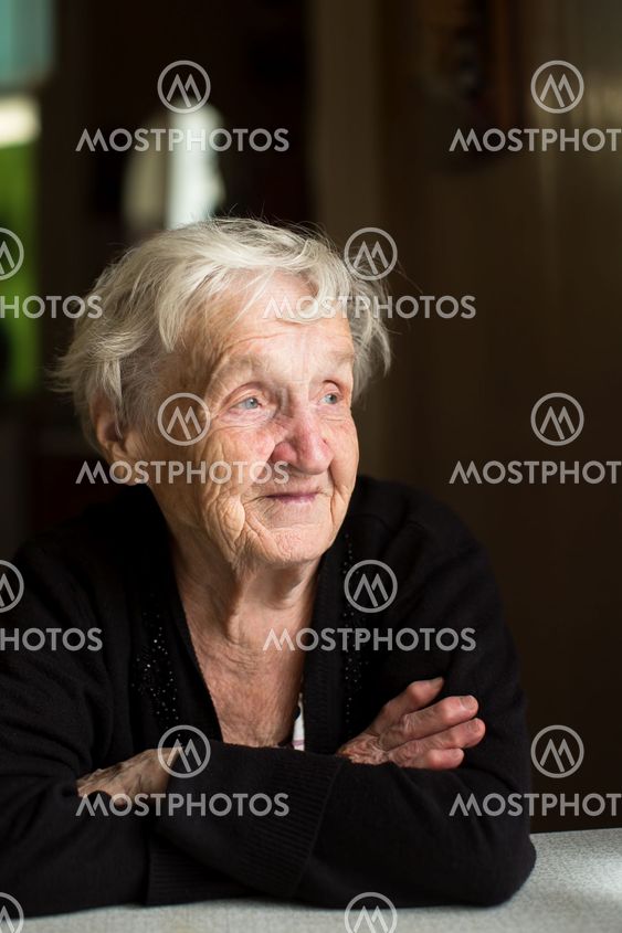 An elderly woman sitting at the table.