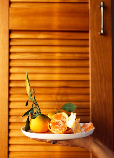 A close-up of a female hand with a ceramic white plate...