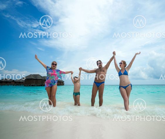 Family swims against the beautiful tropical island