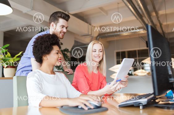 happy creative team with computer in office