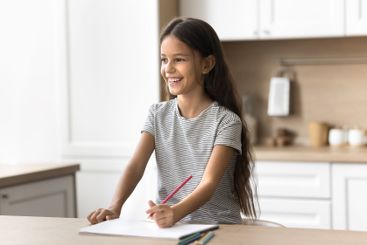 Preteen age girl look aside with colored pencil in hand