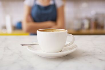 Waitress, coffee and closeup of cup in cafe for...