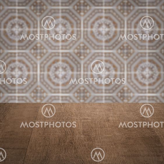 Wood table top and blur vintage ceramic tile pattern wall