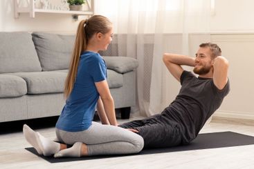 Young couple training at home on quarantine, free space