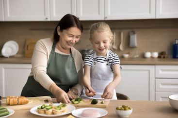 Loving older granny teach to cook little grandkid girl