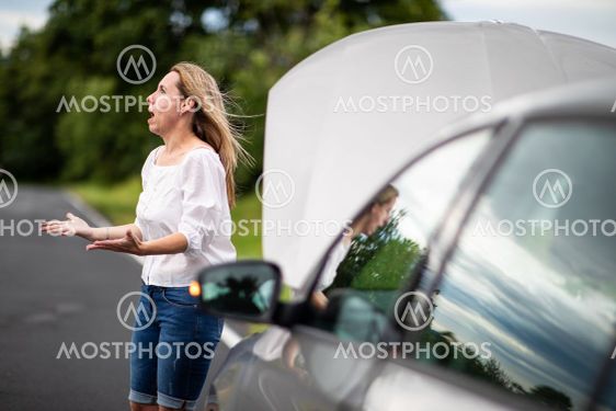 Pretty middle aged woman having car troubles - broken...