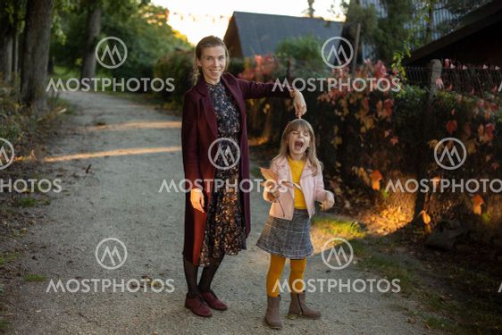 A naughty 7 year old girl in a colorful jacket cries and...