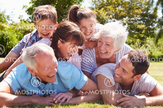 Multi Generation Family Piled Up In Garden Together