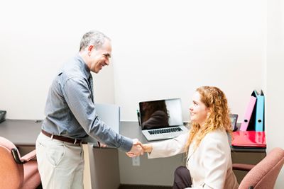Man and woman shaking hands in office