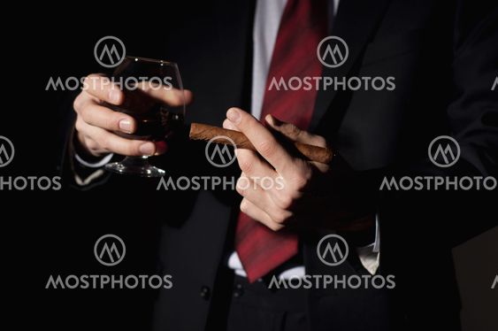 rich person, holds a cigar and whisky