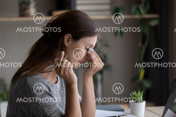 Side view tired woman taking off glasses, massaging nose...