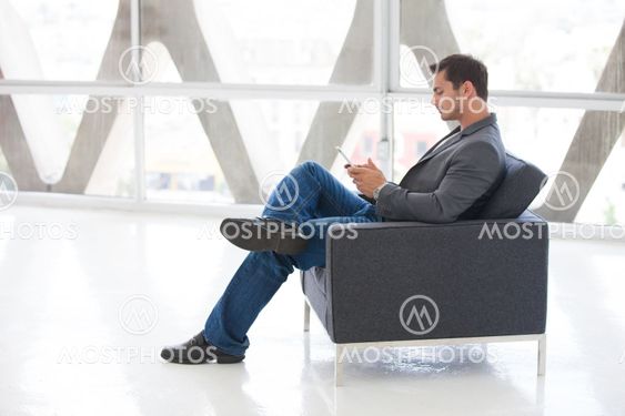 Good looking man in his 20s working on a mini think pad
