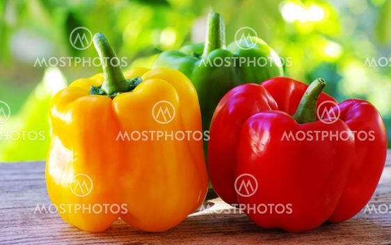red, yellow and green pepper on table,green background