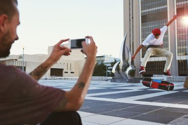 Man, skateboard and picture with camera for jump trick,...