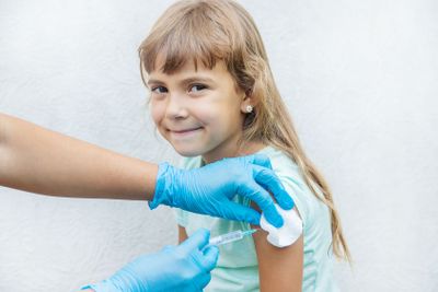 The doctor gives the child an injection in the arm....