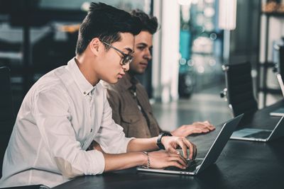 side view of multicultural businessmen working at table...
