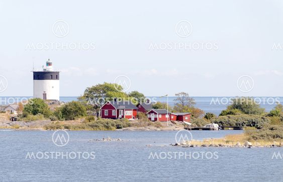 Lighthouse and some small red cottages on a tiny island...