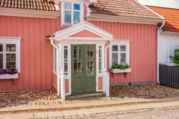 Idyllic pink cottage on a street in a Swedish city