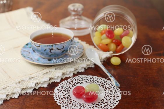 Tea with coloured sugar candies in a glass can