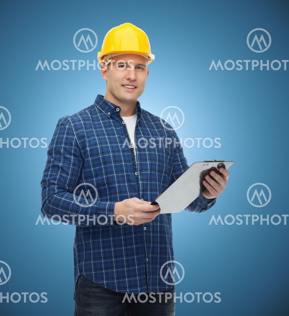 smiling male builder in helmet with clipboard