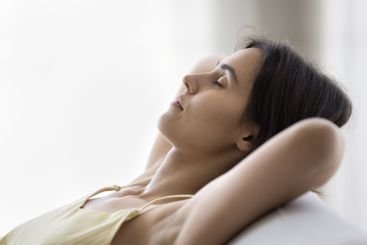 Carefree beautiful teen girl resting on sofa with closed...