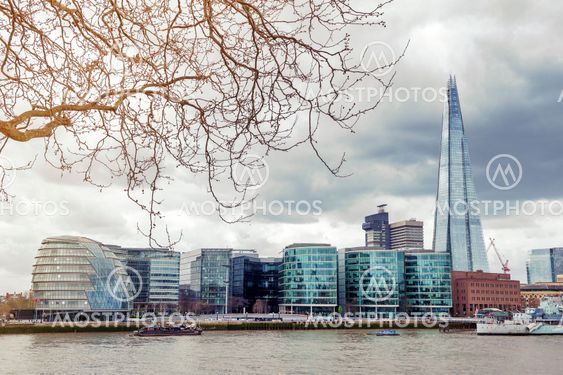 London, UK - April 2018: The curved glass building in spherical shape of the City Hall of London and The Shard, the tallest building in the UK, iconic architectural landmarks of London located on the Southwark bank of the River Thames near Tower Bridge, E