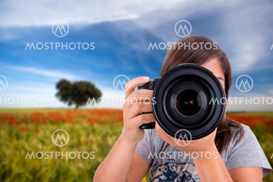 young woman with landscape as background taking photos