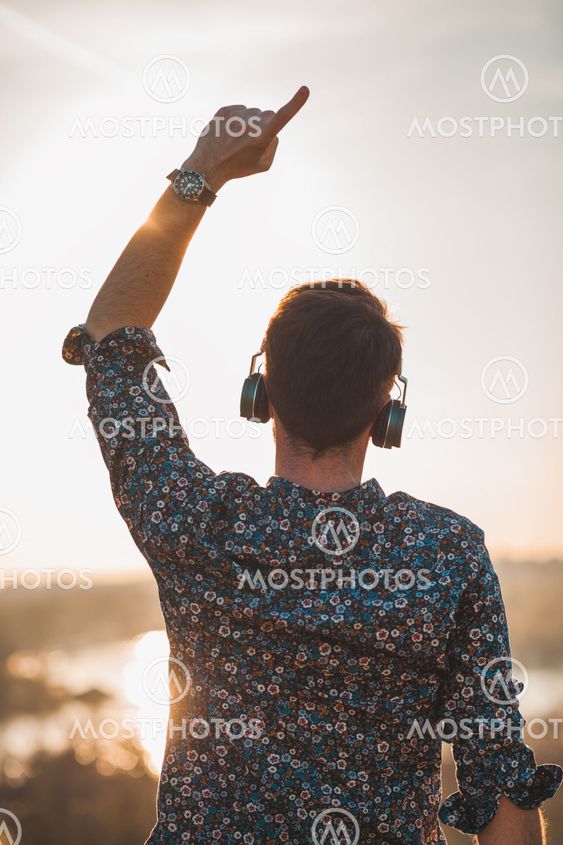 Young man enjoying listening to the music on headphones...