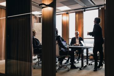 Businesswoman explaining strategy to smiling colleagues...