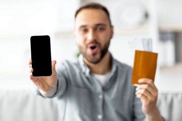 Best online vacation booking app. Caucasian guy holding...