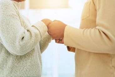 Worship, praying or couple holding hands together in a...
