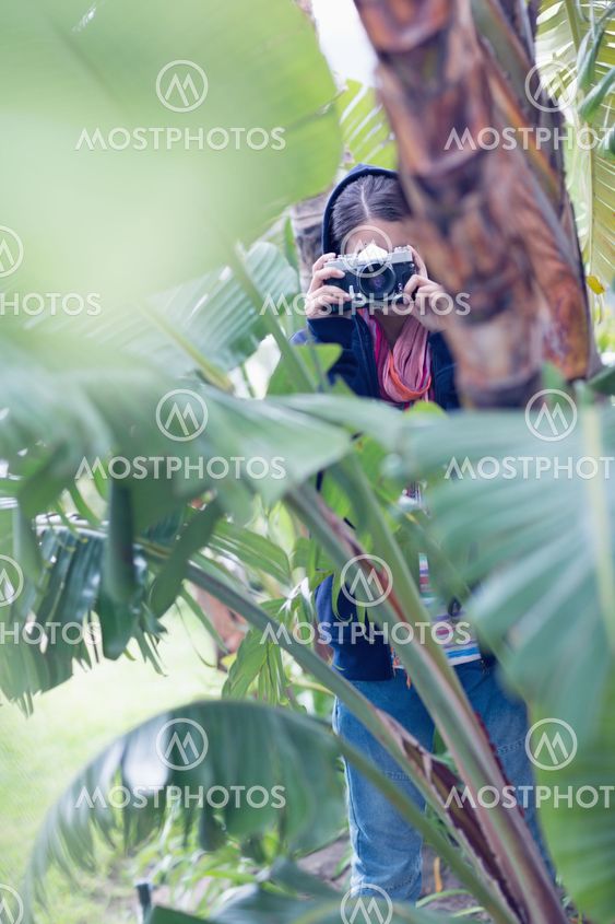Young brunette taking a picture in a forest