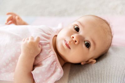 sweet baby girl lying on knitted blanket
