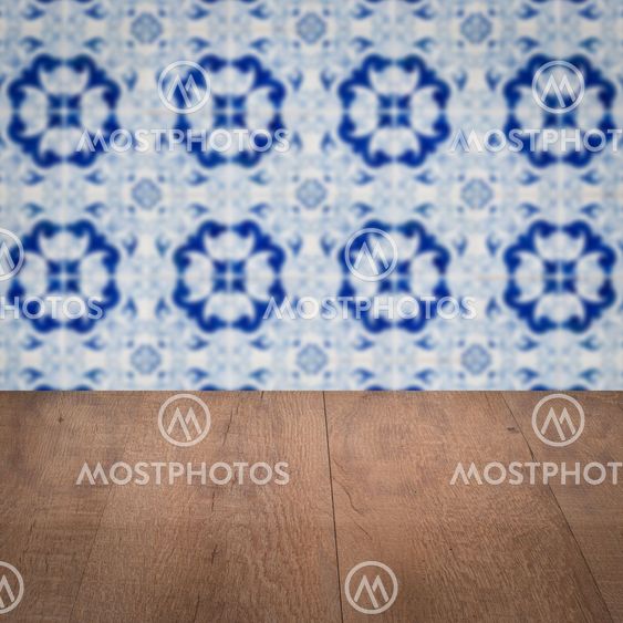 Wood table top and blur vintage ceramic tile pattern wall