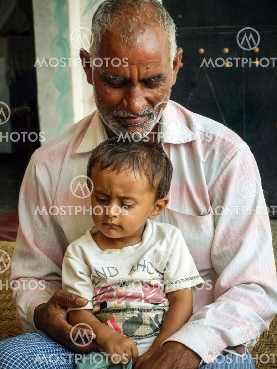 Grandfather with his grandson as they are sitting together