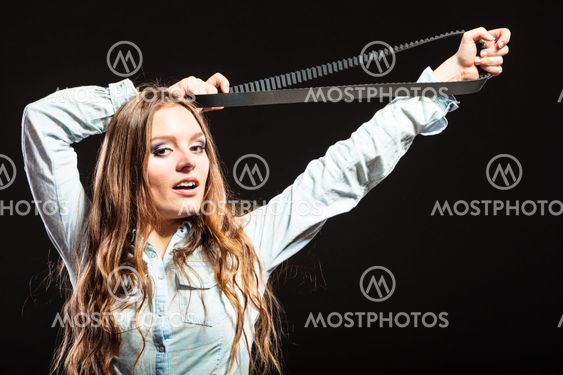 Sexy alluring woman holding fan belt. Feminism.