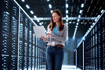 Young woman in data center configuring AI technology