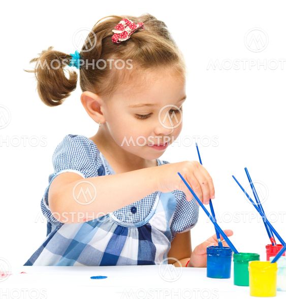 Little girl is painting with gouache