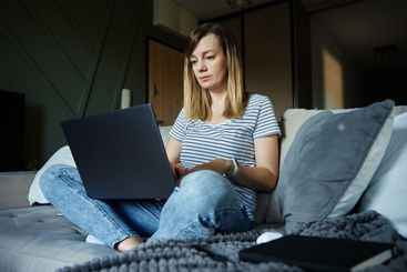 Woman at home using laptop. Remote work at home office