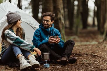 Glad young european couple tourists in jackets rest in...