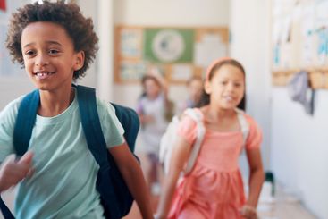 Boy, children and running in hallway at school, happy...