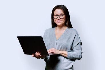 Smiling middle aged woman using laptop on white background