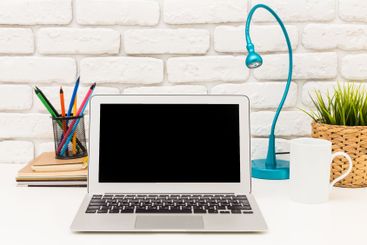 Modern workspace setup with laptop, stationery, and...