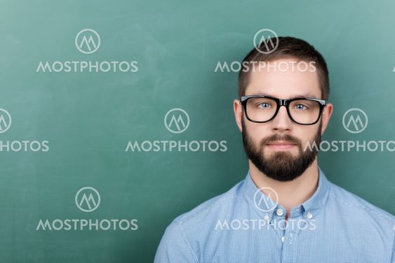 Student Wearing Eyeglasses Against Chalkboard