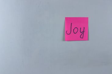 Sticky note with Joy written on it, affixed to a white...